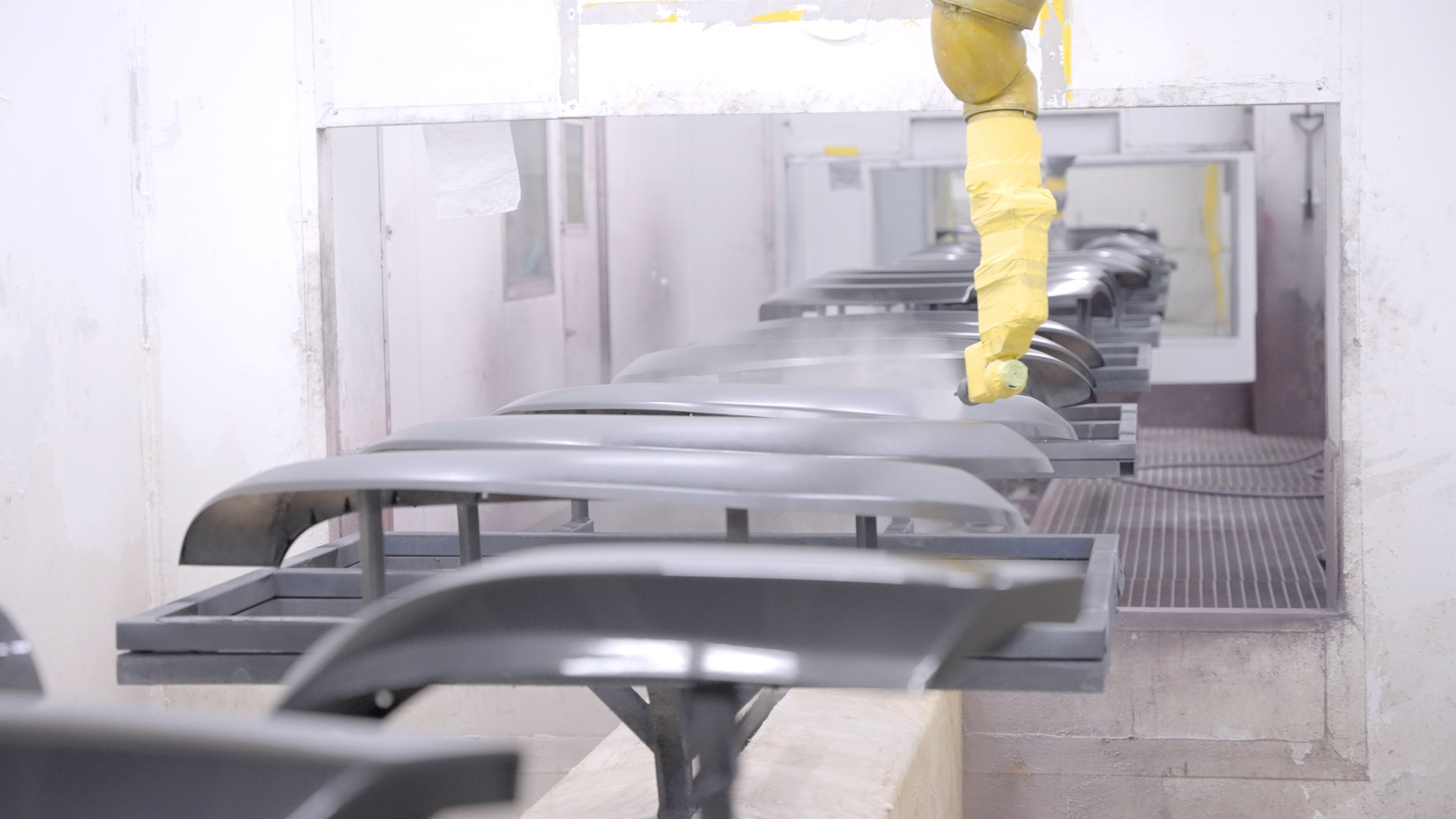 Operator spray-finishing moulded accessory panels on the production line