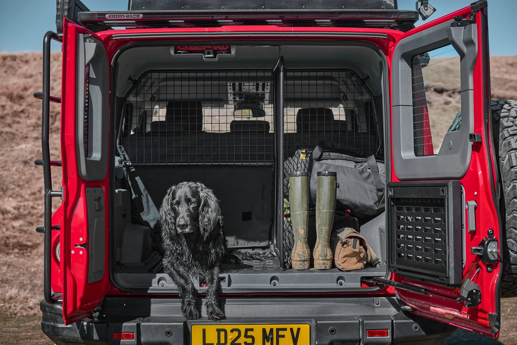 INEOS Grenadier with both rear doors open, showing the load space and cargo barrier